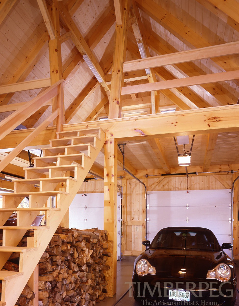 Garage Barn (5857) interior view with car, stacked wood, and stairs to loft