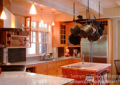 Waterville Valley kitchen with hanging cookware and small island with sink