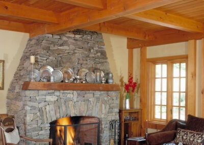 Hawk Mountain (5750) living room featuring timber frame and large stone and brick fireplace