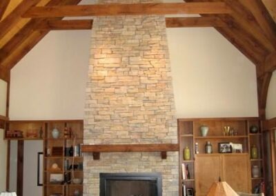 Southeast, WI (T00440) great room with large stone fireplace and timber frame cathedral ceiling