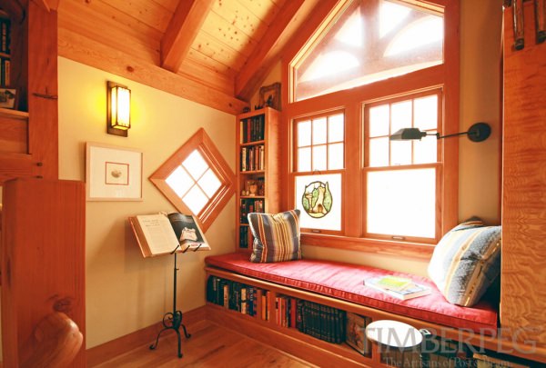 Large window seat with built in bookshelves under and around it.