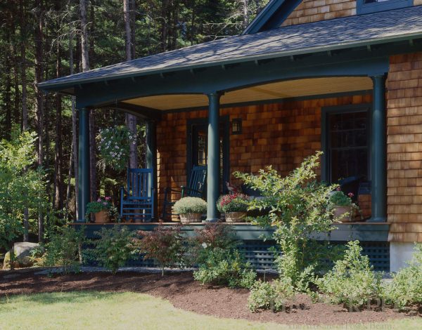 Porch with rocking chairs and trees and shrubs in garden