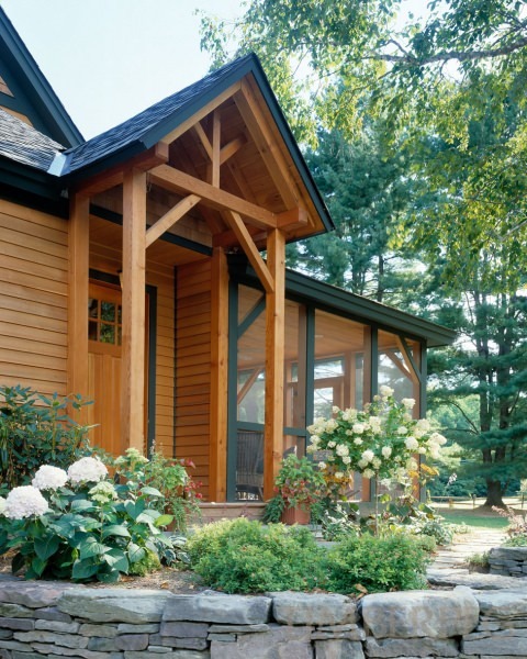 Front entryway with timber frame and small garden along stone wall