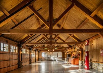 Lake Winnipesaukee Waterfront Retreat garage interior featuring stonework and timber frame.