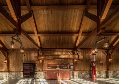 Lake Winnipesaukee Waterfront Retreat garage interior featuring stonework and timber frame.
