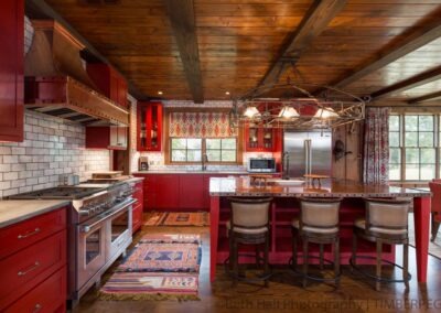 Hunting Lodge AR (T01240) kitchen featuring red cabinetry, white washed brick backsplash and coppertop island