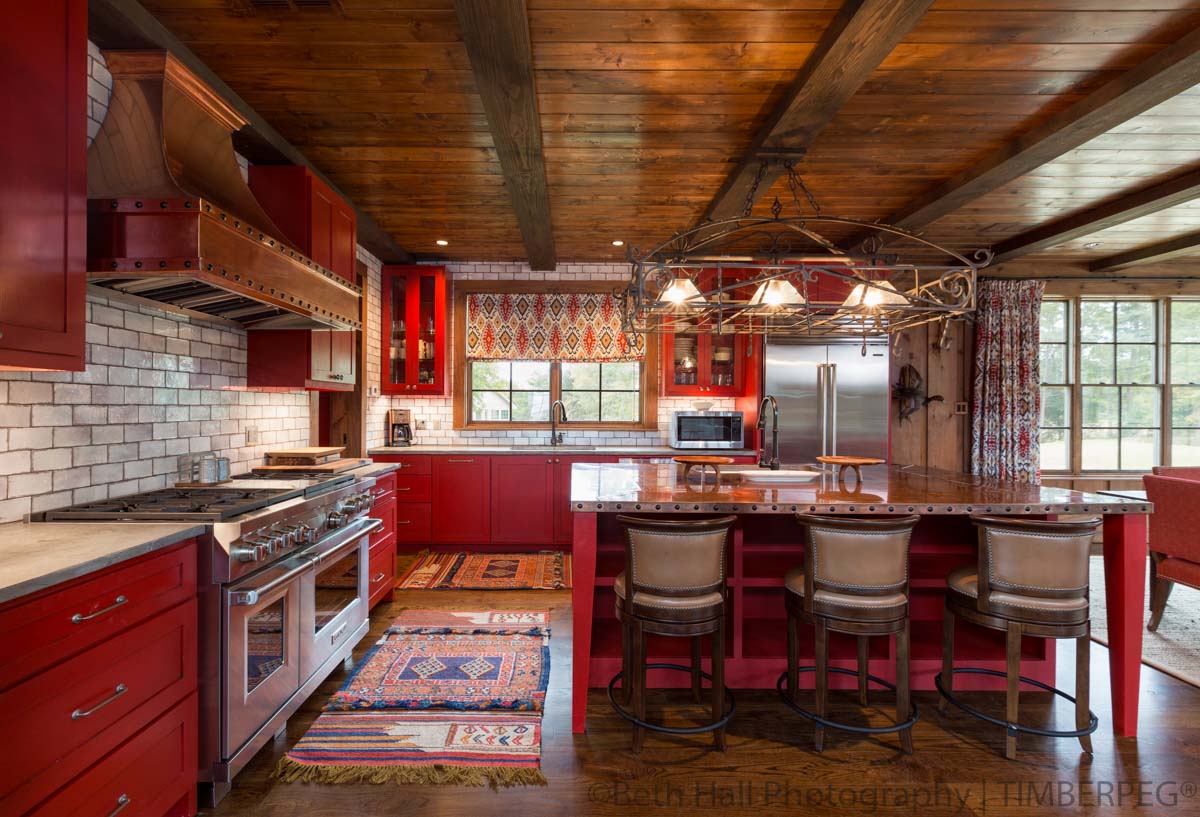 Hunting Lodge AR (T01240) kitchen featuring red cabinetry, white washed brick backsplash and coppertop island