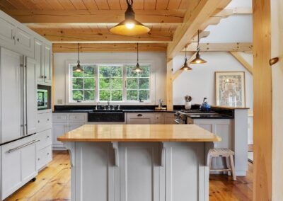 Old Chatham Barn Home with wood beams and a wooden island in the kitchen.