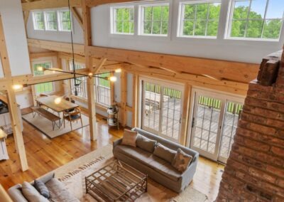 An Old Chatham Barn Home featuring wood beams and windows in their living room.
