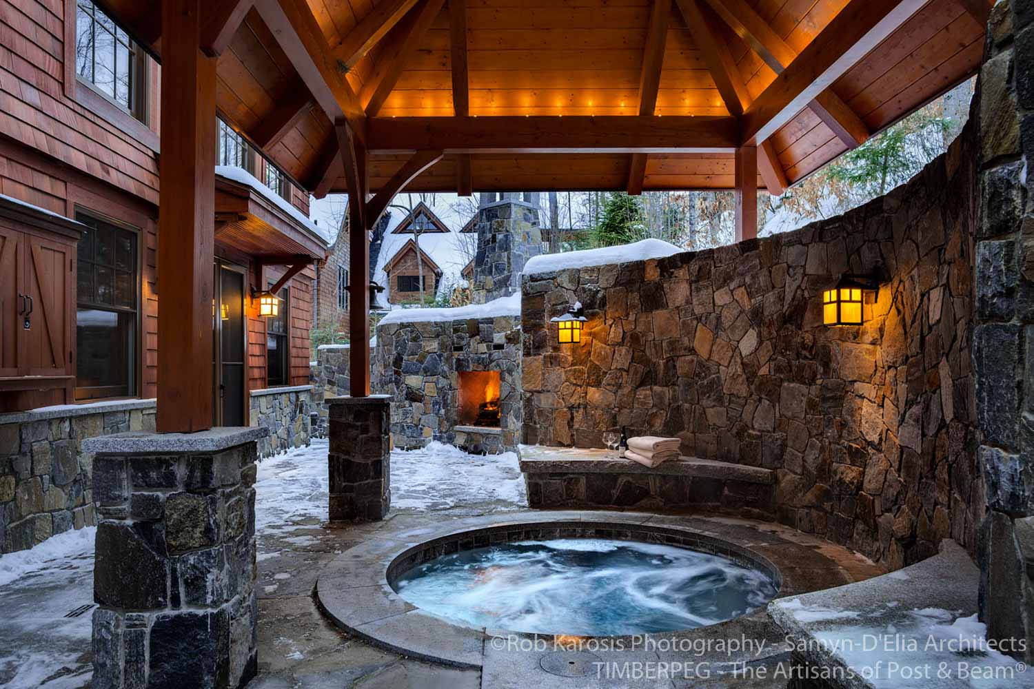 A stone hot tub in a snow covered backyard, perfect for Santa.