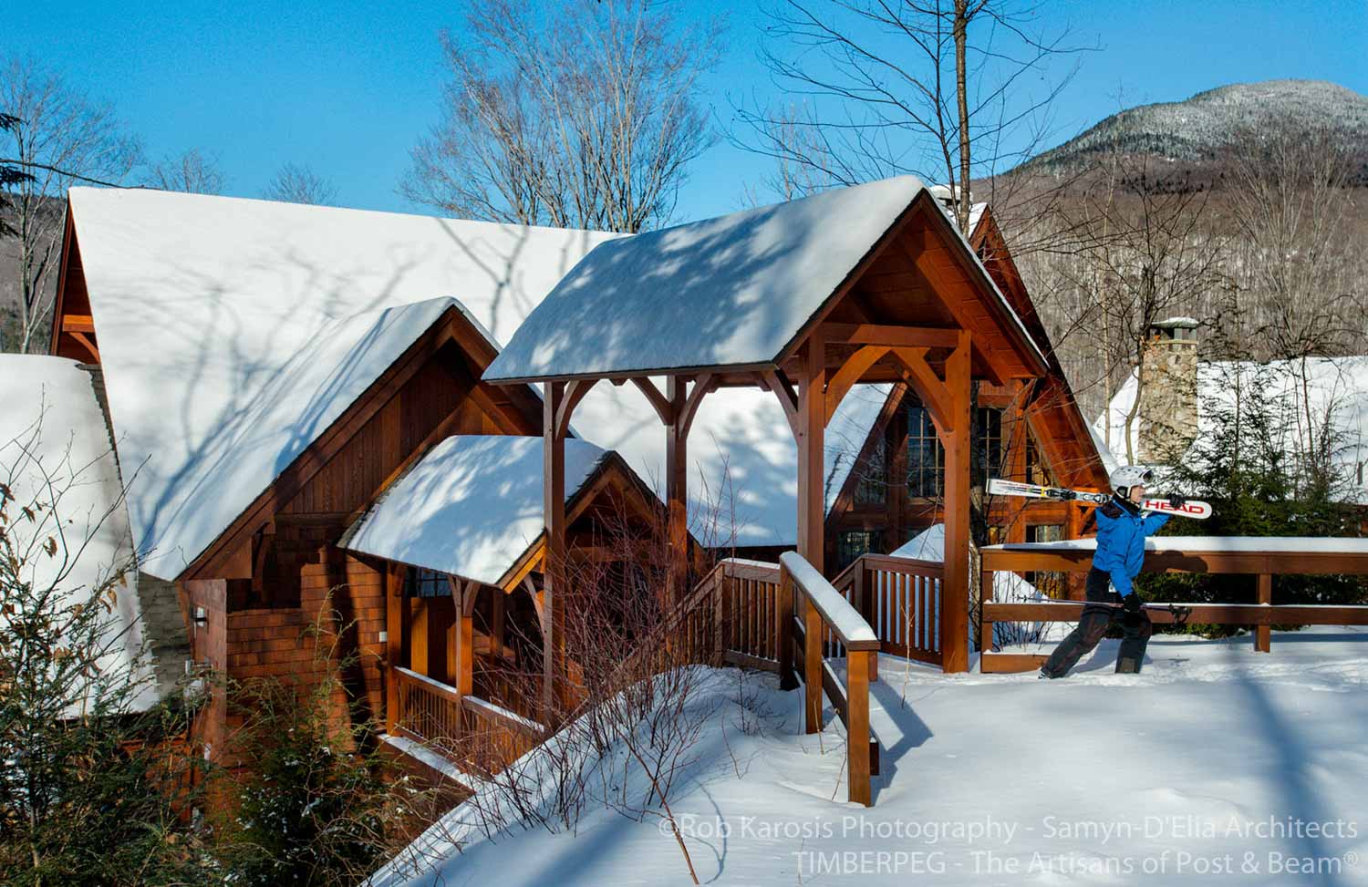 Loon Mountain Ski Home covered walkway to ski trails with skier walking and carrying skis