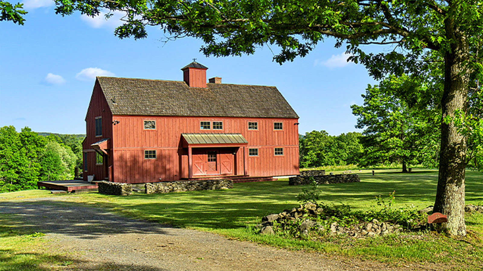 exterior view of red barn home with cupola